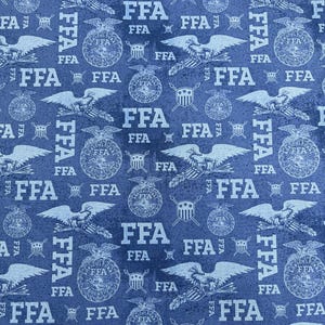 May include: Blue fabric with a repeating pattern of the letters "FFA", eagles, and emblem designs. The white text and illustrations are set against a textured, dark blue background. The fabric is likely for crafting or apparel.