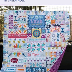 May include: A colorful quilt with the text "Dear Diary" and "BY SHERRI NOEL". The quilt features various inspirational phrases like "Love Yourself", "Be Fearless", and "Be Nicer". It measures 84 x 84 inches.