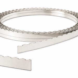 May include: A coiled strip of silver-toned metal featuring a decorative scalloped edge along one side. The metal band is smooth and reflective, wound into a circular shape with one end extending outward, showcasing the consistent wavy pattern.