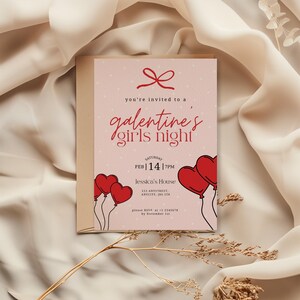 Op de afbeelding: Een roze Galentine's Girls Night uitnodiging met rode hartballonnen en een strik. De uitnodiging bevat de datum, tijd en locatie. De tekst luidt: "je bent uitgenodigd voor een Galentine's Girls Night."