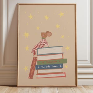 Puede incluir: Una lámina enmarcada sobre fondo beige que muestra un ratón marrón con pijama de rayas rojas y blancas sentado sobre una pila de libros. Los libros incluyen los títulos Harry Potter, Paddington y El Principito, rodeados de estrellas amarillas.
