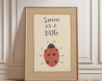 Puede incluir: Lámina enmarcada con una mariquita de dibujos animados y el texto "SNUG AS A BUG". La mariquita es roja con lunares negros y una cabeza negra. La obra de arte está enmarcada en un marco marrón claro.