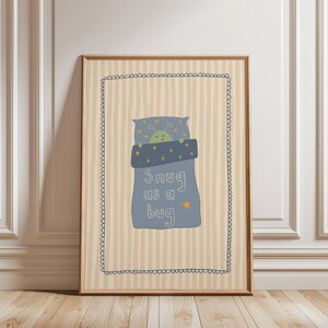 May include: A framed print with a charming illustration of a green bug in a blue bed, with the words "Snug as a bug." The background has vertical beige stripes and a decorative border, suitable for a child's room.