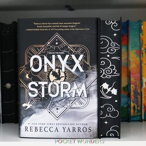 Puede incluir: Una portada de libro en blanco y negro con el título "ONYX STORM" en letras blancas en negrita. El libro es de la autora número 1 de bestsellers del New York Times Rebecca Yarros. La portada presenta un cielo oscuro y tormentoso con una silueta de dragón y una cita de Christopher Paolini, autor de la serie Inheritance Cycle.