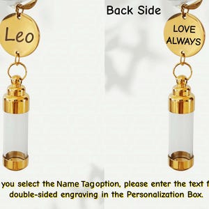 May include: A gold-colored vial pendant with a clear glass body. The front side features a gold disc with the name "Leo" engraved, while the back side says "LOVE ALWAYS". The pendant has a decorative gold top.