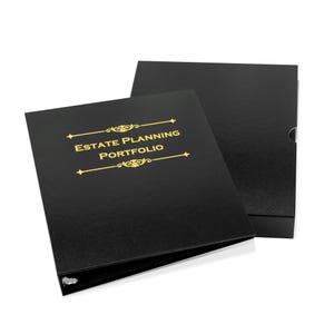 May include: Black estate planning portfolio with gold lettering and decorative accents. The text "ESTATE PLANNING PORTFOLIO" is centered on the front cover. The portfolio is open, revealing the interior, and is next to a matching black box.