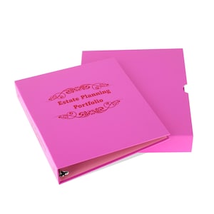 May include: A bright pink binder with the words "Estate Planning Portfolio" in a decorative font. The binder is open, revealing a light pink interior, and sits next to a matching pink box.