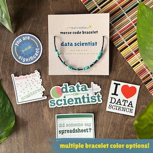 May include: A Morse code bracelet with turquoise and black beads on a display card labeled 'data scientist', surrounded by five stickers featuring data science themes, including 'you are significant', 'feeling a bit scattered', and 'I love data science'.