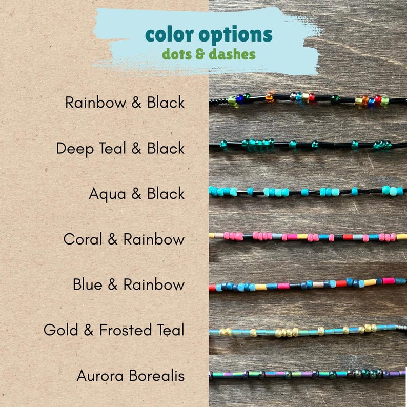 May include: A display of seven beaded strands labeled color options dots & dashes. The strands feature various color combinations including rainbow and black, deep teal and black, aqua and black, coral and rainbow, blue and rainbow, gold and frosted teal, and aurora borealis.