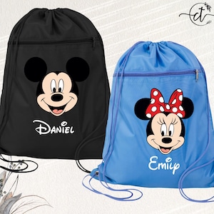 May include: Two drawstring backpacks, one black and one blue. The black bag features Mickey Mouse with the name "Daniel" below. The blue bag features Minnie Mouse with a red polka dot bow and the name "Emily". Both bags have a zippered front pocket.
