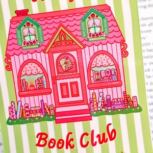 Illustration of a whimsical pink cottage labeled "Strawberry Cottage Book Club," adorned with books, strawberries, and green striped background.