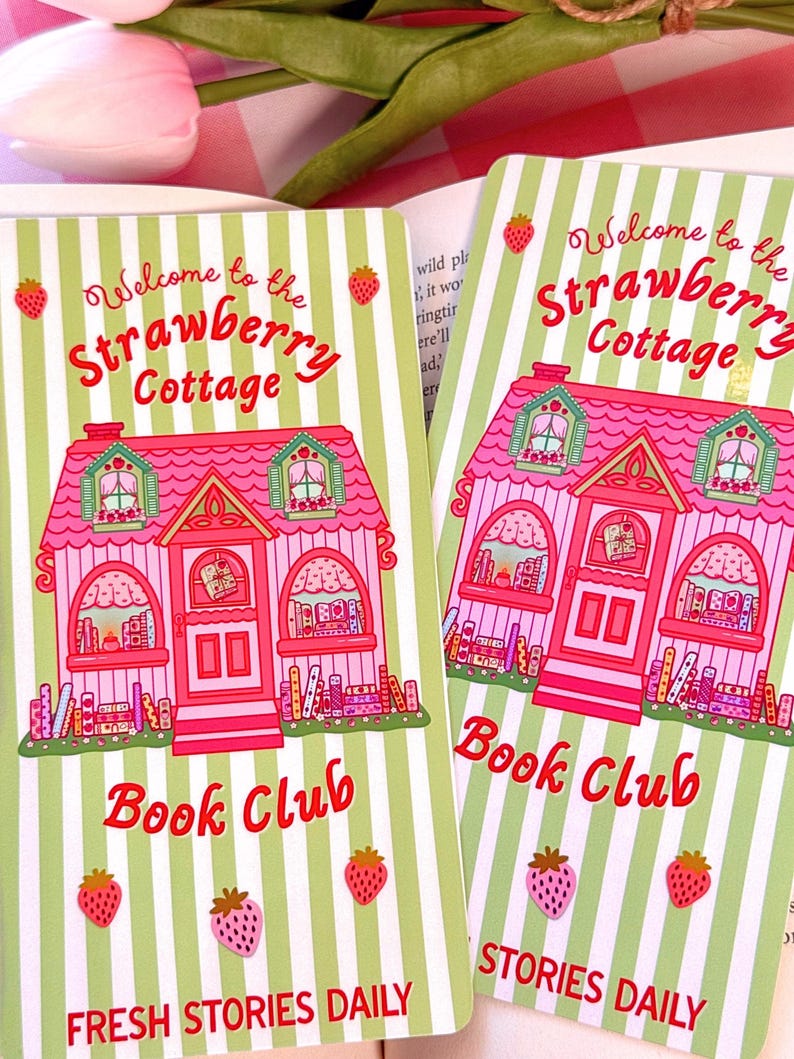 side by side bookmarks, bookmarks have illustrated pink strawberry and book theme cottage, with text: "welcome to the strawberry cottage book club, fresh stories daily"