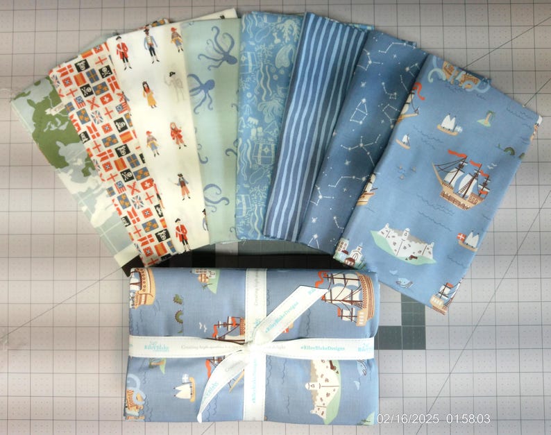 K&ouml;nnte beinhalten: Ein Set aus zehn Stoffquadraten mit verschiedenen nautischen Motiven. Die Quadrate sind in Blaut&ouml;nen, Wei&szlig; und Rot gehalten und zeigen Illustrationen von Schiffen, Sternen und anderen nautischen Motiven.