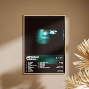 May include: A rectangular wall poster featuring a black background with a blurred teal figure at the top. The text reads Lost Weekend by Phoebe Bridgers, listing sixteen tracks, a 52:42 run time, and an August 14, 2026 release date by Dead Oceans.