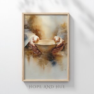 Peut inclure: Impression d'art encadrée, aquarelle. L'œuvre représente une paire de mains tenant un bol doré. L'image a une palette de couleurs chaudes et le texte "HOPE AND HUE" en bas.