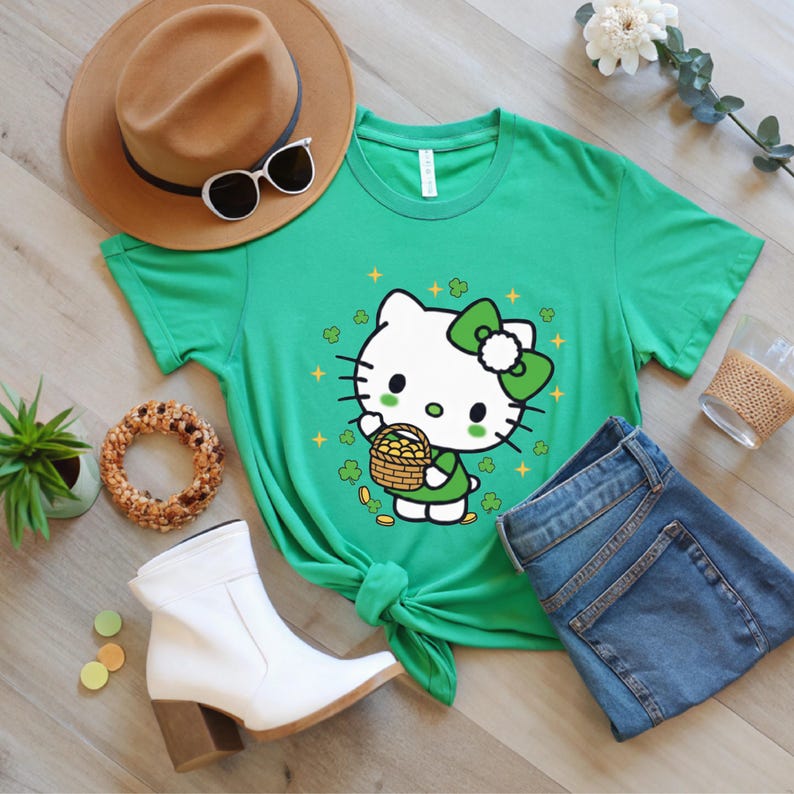 May include: A green t-shirt featuring a cartoon character holding a basket of gold coins, with shamrocks and stars. The shirt is paired with blue jeans, a brown hat, sunglasses, and white boots. A St. Patrick's Day theme.