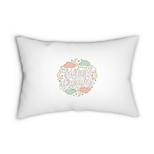 May include: White rectangular pillow featuring the words "Sweet dreams" in a circular design. The design incorporates pastel-coloured clouds, moons, and stars. The pillow is a soft, decorative item.