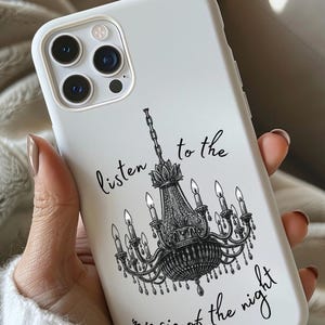 May include: White phone case featuring a black chandelier design with the text "listen to the music of the night." The case has a glossy finish and a protective bumper around the edges.