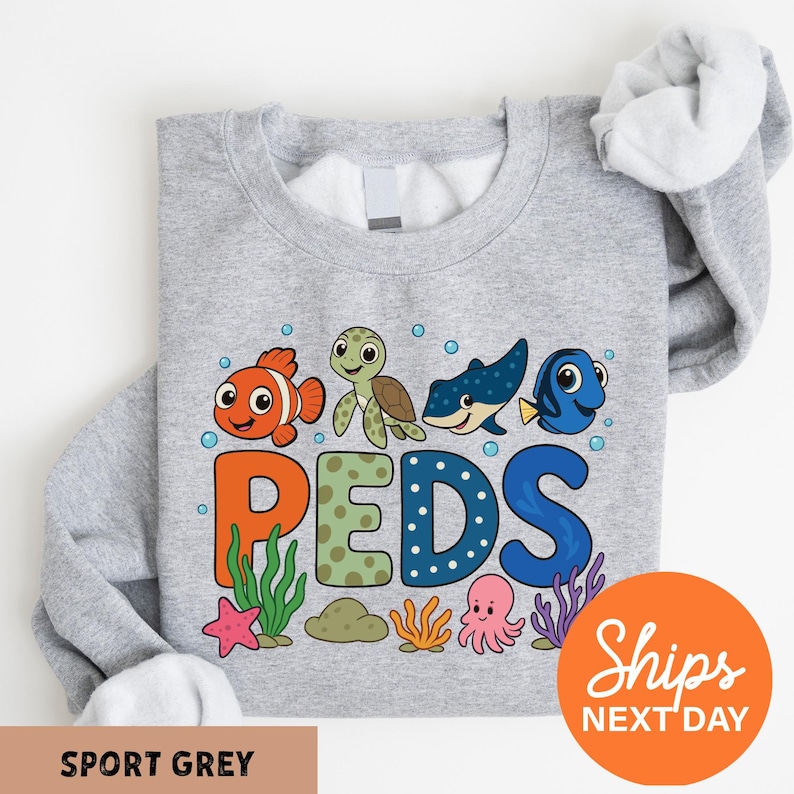 A gray sweatshirt with a colorful graphic design featuring cartoon sea animals and the word "PEDS" printed on it.