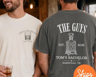 以下が含まれることがあります： ウィスキーグラスの小さなグラフィックと「TOM'S BACHELOR EST. 2026」の文字が胸元にあるクリーム色のTシャツと、ウィスキーデキャンタの大きなグラフィックと「THE GUYS EST. 2026 TOM'S BACHELOR NASHVILLE, TN.」の文字があるチャコールグレーのTシャツ。