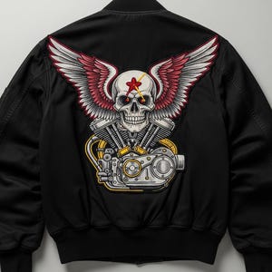 Może przedstawiać: Czarna kurtka bomberka z dużą, haftowaną naszywką na plecach. Naszywka przedstawia czaszkę z czerwoną gwiazdą, skrzydłami i silnikiem motocyklowym. Skrzydła są biało-czerwone. Kurtka ma prążkowany kołnierz i mankiety.