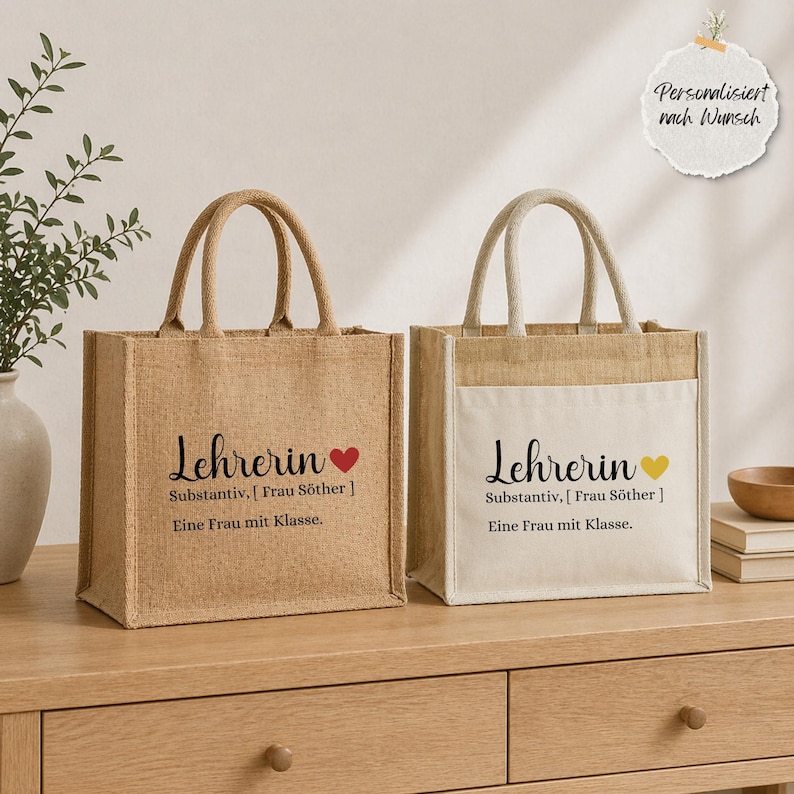 May include: Two rectangular jute tote bags with sturdy handles. The left bag is natural tan jute, the right has a white canvas front pocket. Both feature black text: "Lehrerin Substantiv, [ Frau S&ouml;ther ] Eine Frau mit Klasse." with a heart icon.