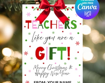 以下が含まれることがあります： 赤いリボンが付いた白いギフトタグ。緑と赤のテキストで「TEACHERS like you are a GIFT!」と「Merry Christmas & Happy New Year」と書かれています。タグは雪の結晶と点で飾られています。