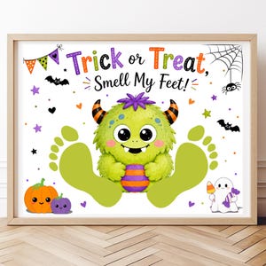 Può includere: Una stampa rettangolare in una cornice di legno chiaro con un mostro verde che tiene una palla a righe, affiancato da due grandi impronte verdi. Il testo recita Trick or Treat, Smell My Feet! con icone di Halloween come pipistrelli.