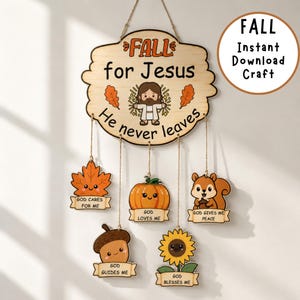 Op de afbeelding: Een houten wandhanger met een centraal bord met de tekst FALL for Jesus He never leaves en een cartoonfiguur. Vijf kleinere houten vormen hangen eronder, met afbeeldingen van een esdoornblad, pompoen, eekhoorn, eikel en zonnebloem met tekst.