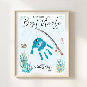 May include: Framed art print with a light blue watercolor background. The print features a handprint fish design with a fishing rod, the text "I Caught The Best Uncle Ever!" and "Happy Father's Day 2026".