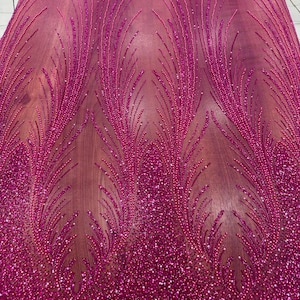 Tessuto in pizzo con perline fucsia: motivo ad ali d'angelo