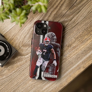 May include: A smartphone case featuring a football player in a red and black uniform with the number 7. The case has a red and white striped design and the name "BIJAN ROBINSON" is printed on the bottom.