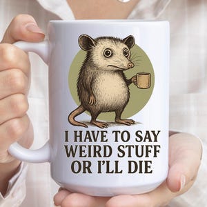 Funny possum mug featuring a cartoon possum holding a cup with a weird stuff quote; quirky office humor mug, coworker gift.