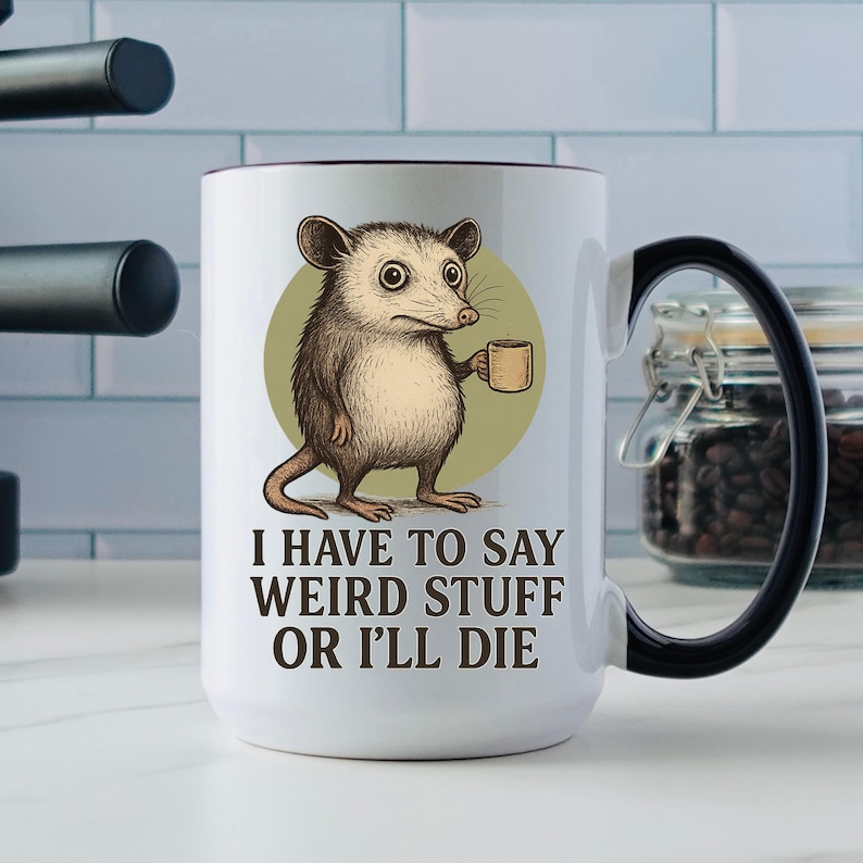 Funny possum mug featuring a cartoon possum holding a cup with a weird stuff quote; quirky office humor mug, coworker gift.