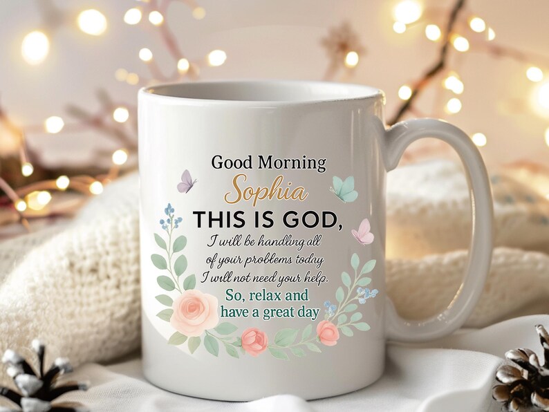 Personalized white ceramic christian coffee mug with gold name Sophia, pastel floral border, good morning Bible verse style text.