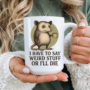 Funny possum mug featuring a cartoon possum holding a cup with a weird stuff quote; quirky office humor mug, coworker gift.