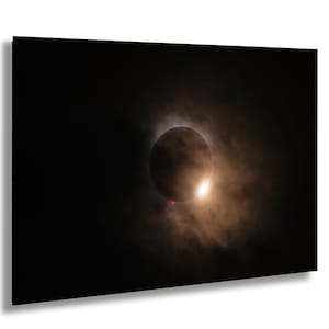Peut inclure: Impression sur toile d'une éclipse solaire. La lune occulte le soleil, créant un cercle sombre entouré d'une couronne brillante. Le ciel est sombre avec une lueur orangée brumeuse, scène céleste dramatique.