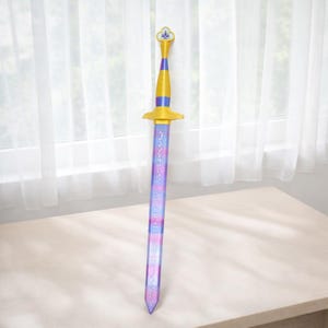 May include: A toy sword with a gold hilt and crossguard, a purple and blue checkered blade, and a decorative finial. The sword is approximately 76 cm long.