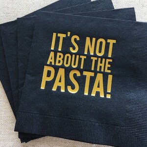 May include: Black paper napkins with gold lettering that reads "It's not about the pasta!"