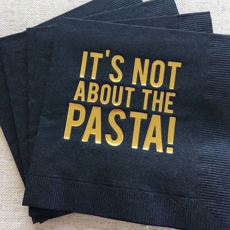 May include: Black paper napkins with gold lettering that reads "It's not about the pasta!"