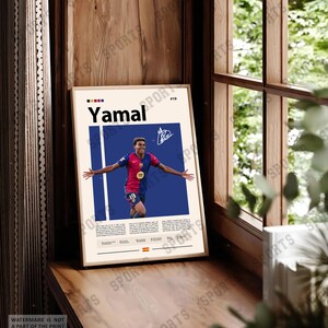 May include: A framed vertical poster featuring a graphic illustration of soccer player Lamine Yamal in a red and blue jersey with the number 19. The design includes the name Yamal, a signature, biographical text, and a small Spanish flag at the bottom.
