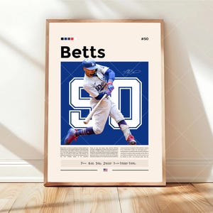 May include: A framed poster featuring a baseball player in a Dodgers uniform mid-swing. The poster has the name "Betts" in bold black letters, the number "50", and a large "90" in blue. The background is a light beige.
