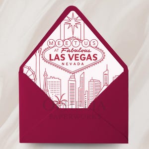 May include: A deep red envelope with a white interior featuring a Las Vegas-themed design. The design includes the words "Meet Us at Fabulous Las Vegas Nevada" and a skyline illustration. The envelope is open, revealing the detailed artwork.
