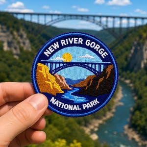May include: A circular embroidered patch featuring a blue border and the text NEW RIVER GORGE NATIONAL PARK. The design depicts a yellow sun, white clouds, a blue river, and brown rocky cliffs beneath a detailed arch bridge illustration.