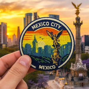 May include: A circular embroidered patch featuring a sunset skyline of Mexico City. The design includes the Angel of Independence monument in yellow and orange, with blue city buildings and the text MEXICO CITY and MEXICO in white lettering.