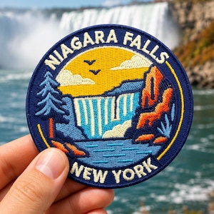 May include: A circular embroidered patch featuring a landscape of Niagara Falls with a yellow sky, blue water, and orange rock formations. The text NIAGARA FALLS is arched at the top and NEW YORK is arched at the bottom in white lettering.