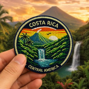 May include: Embroidered patch featuring a Costa Rican landscape with a volcano, waterfall, and palm trees. The patch has a navy blue border with the words "COSTA RICA" and "CENTRAL AMERICA" in white.