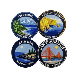 Puede incluir: Cuatro parches redondos bordados con escenas de parques nacionales de EE. UU. Los parches incluyen Olympic con una montaña y un lago, Channel Islands con acantilados, Acadia con una costa y San Francisco con el Golden Gate Bridge.