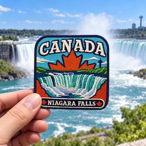 May include: A square embroidered patch featuring a blue sky with the text CANADA in white, a large orange maple leaf, and a depiction of Niagara Falls in shades of blue and white. The bottom border contains the text NIAGARA FALLS in white.