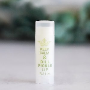 May include: White tube of lip balm with a gold crown and the text "Keep Calm & Dill Pickle Lip Balm".